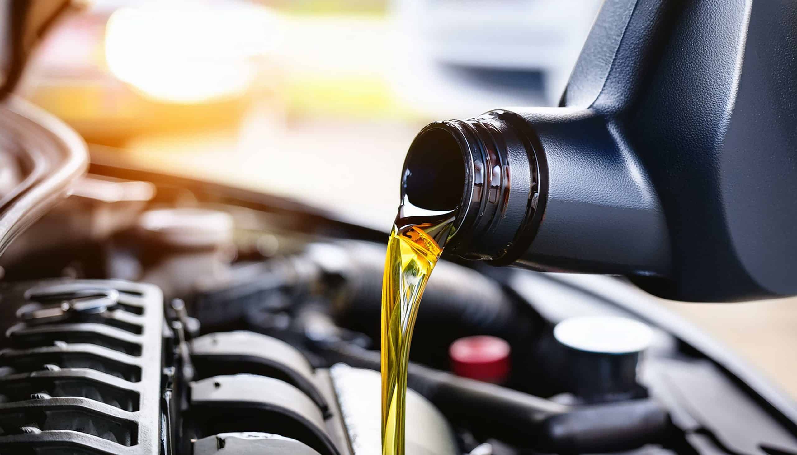 engine oil. Pouring oil motor car lubricant from black bottle on chemicals